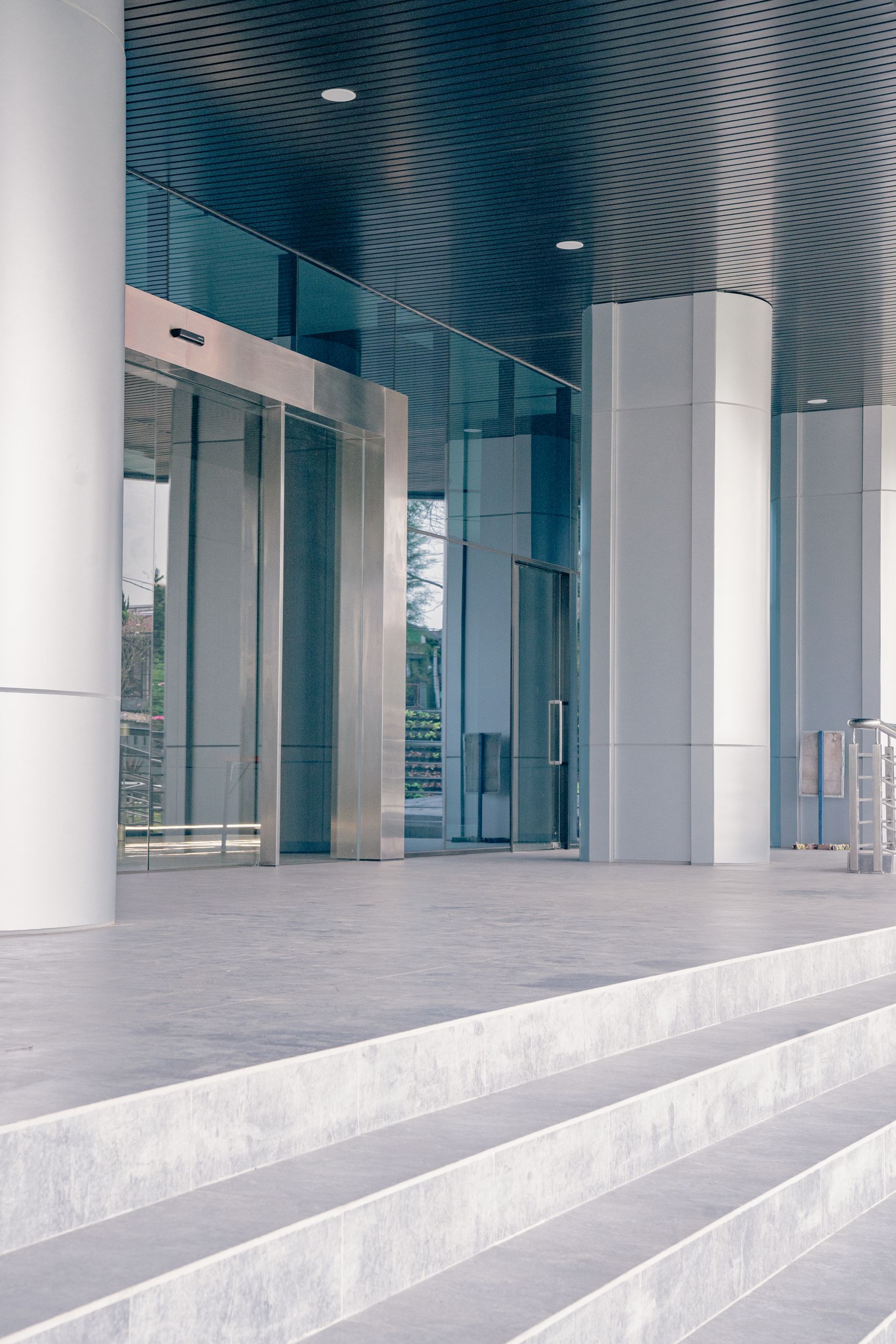 Elegant modern building entrance featuring sleek glass and steel architecture with a minimalist design.